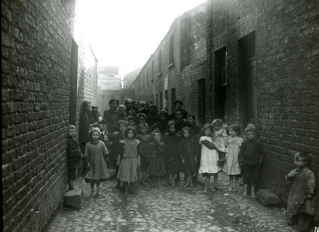 Children and adults in back street of Crozier's Row, 1912. 